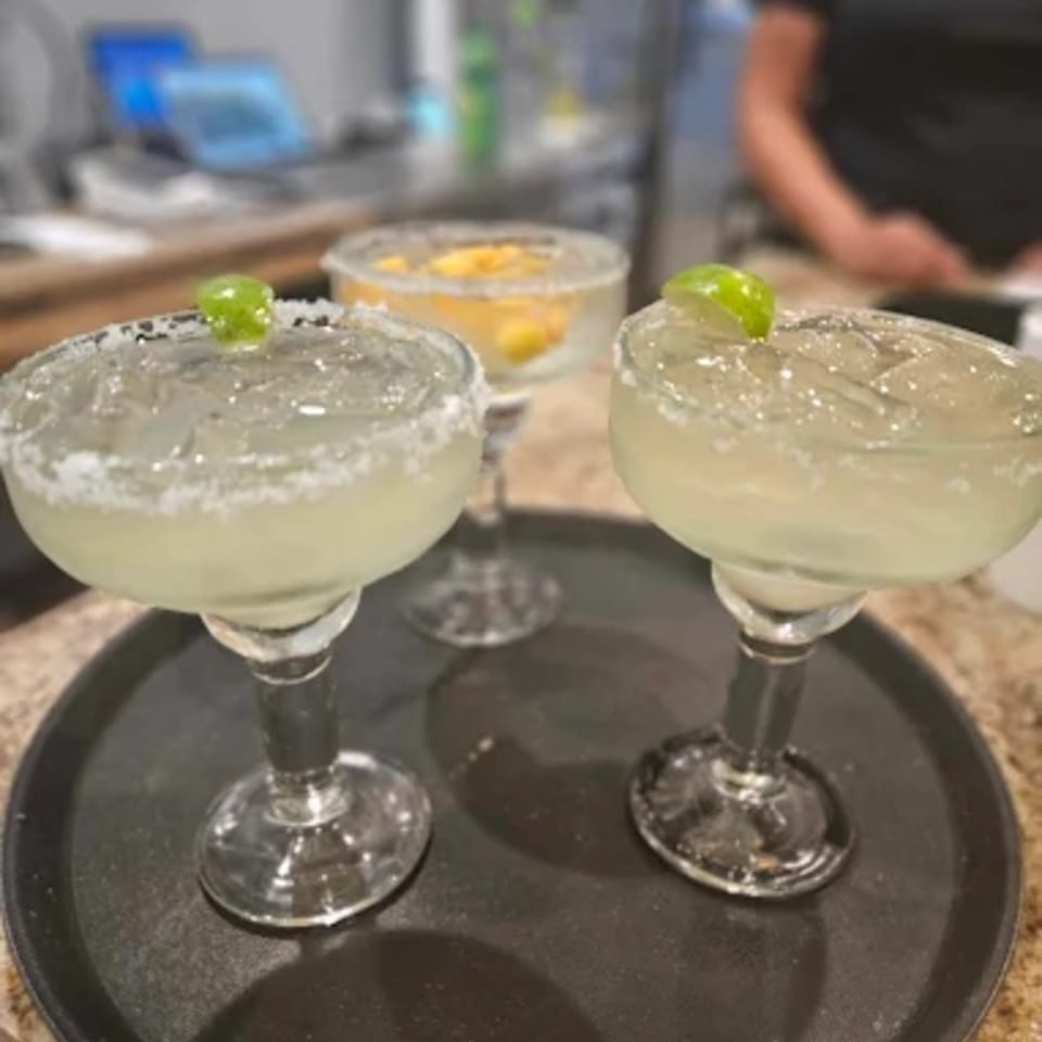 Three margaritas, two lime and one mango, on a black tray at Norma's Cocina.